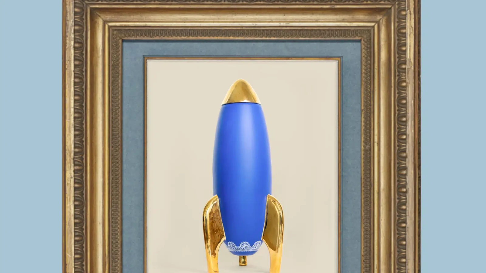 Bouteille-fusée bleue LADY BENZ présentée comme une œuvre dans un cadre doré
